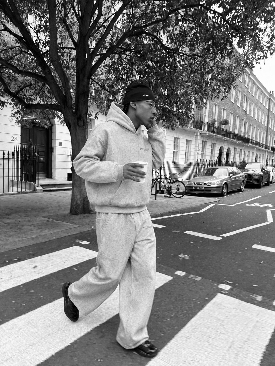 Model in the grey TALVESSO tracksuit crossing a London street